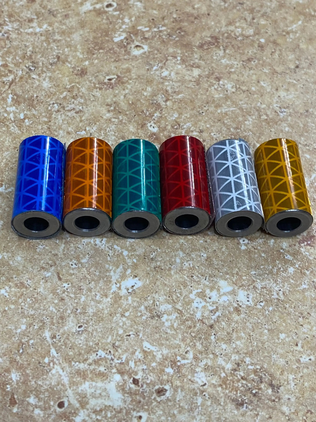 Six colorful Knightmare Shoelace Running Weights with geometric pattern in blue, orange, teal, red, gray, and gold.