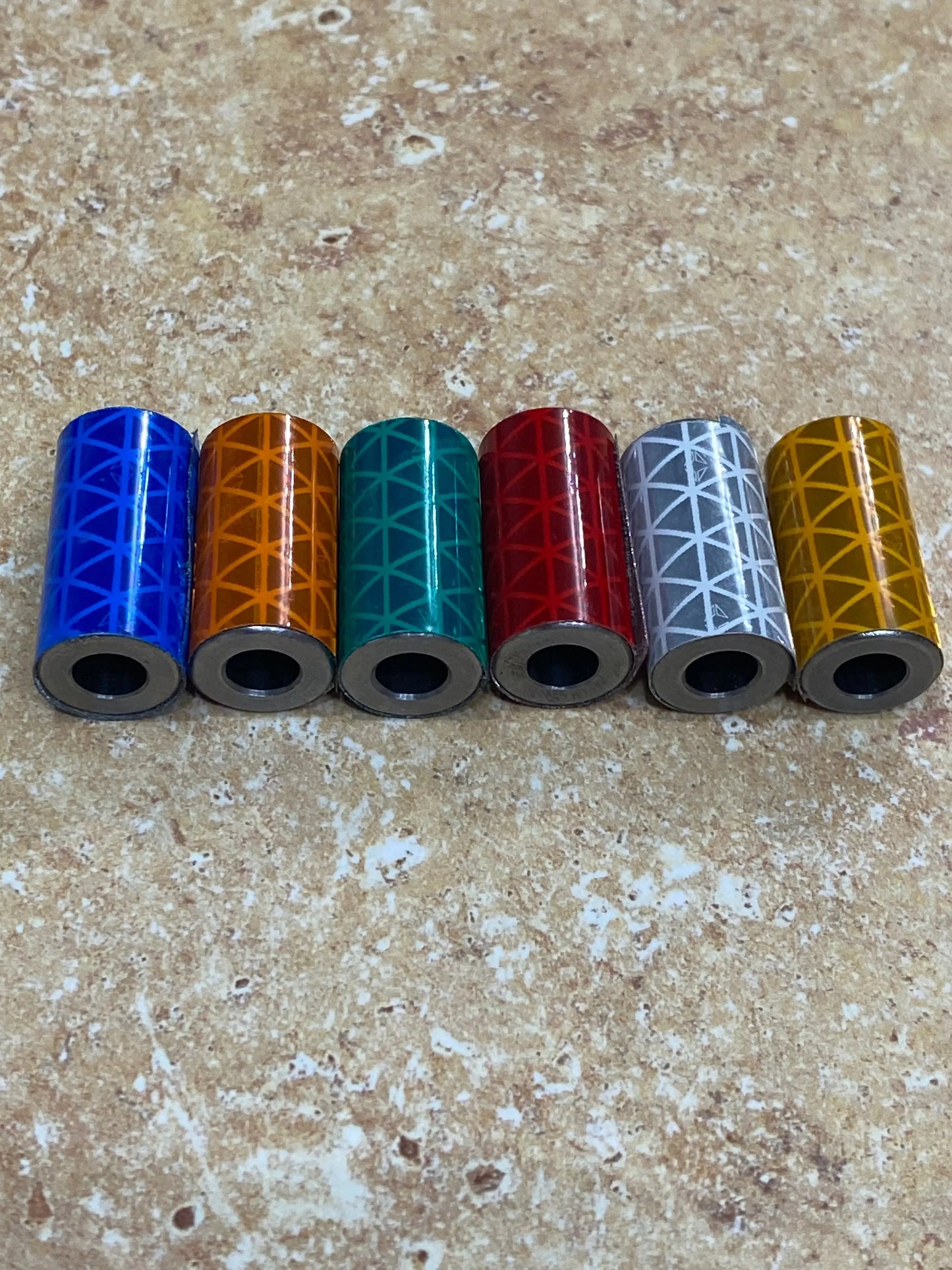 Six colorful Knightmare Shoelace Running Weights with geometric pattern in blue, orange, teal, red, gray, and gold.